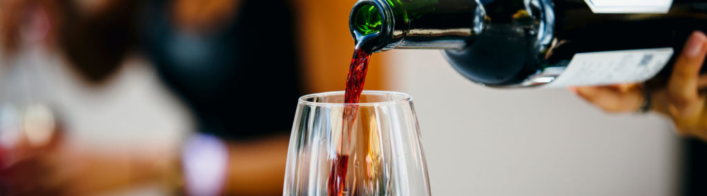 Server pouring wine in glass at Hathaway's Lounge in the Little America Hotel.