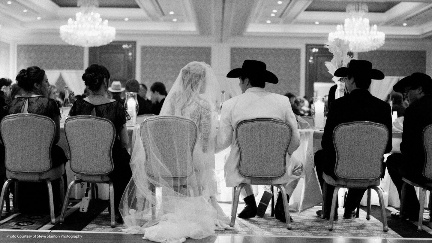 Bride and groom sitting at the head table for their wedding reception.