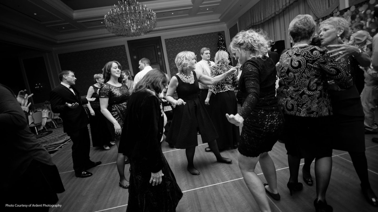 Group of wedding guests dancing at reception