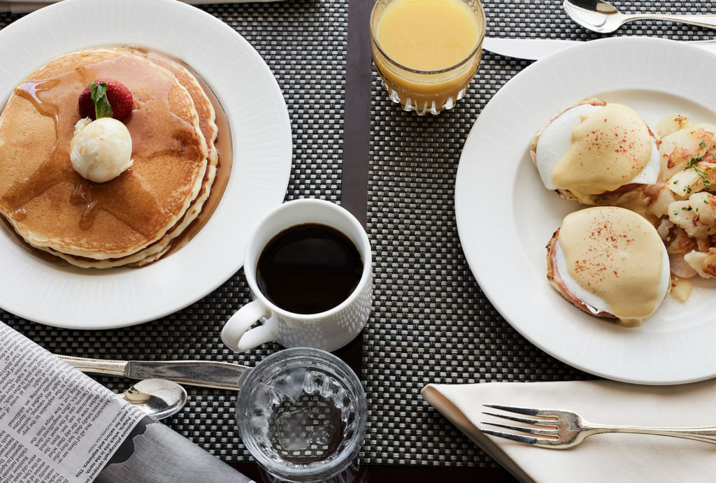 Breakfast items from the Little America Hotel in Cheyenne, Wyoming including Eggs Benedict, pancakes, coffee, and orange juice.