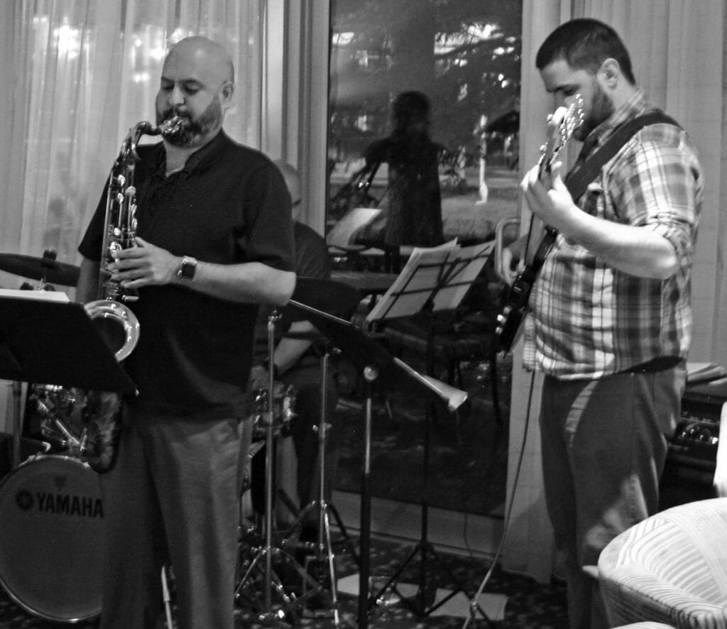 Jazz performers playing bass guitar and saxophone