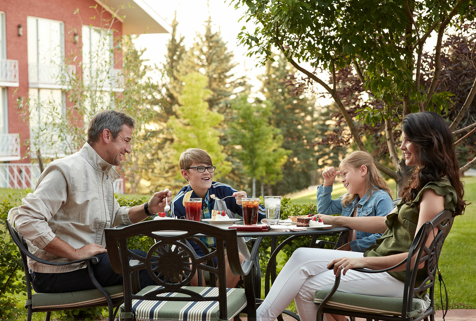 Two adults their kids eating on Hathaway's patio