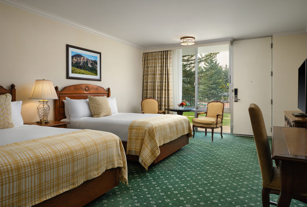 Deluxe queen room with two beds and an extra seating area.