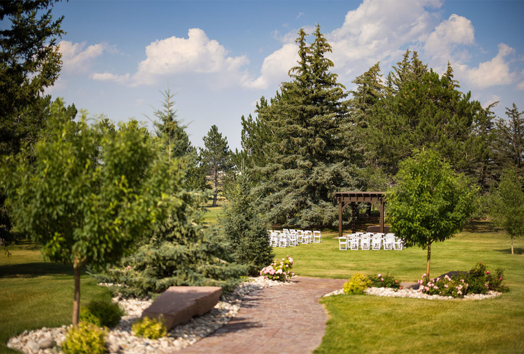 Little America Cheyenne outdoor wedding set up amidst the trees and green grass.