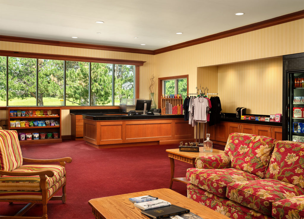 A picture of the pro shop at Little America. There are chairs and a table along with a section of clothing and trinkets for sale.