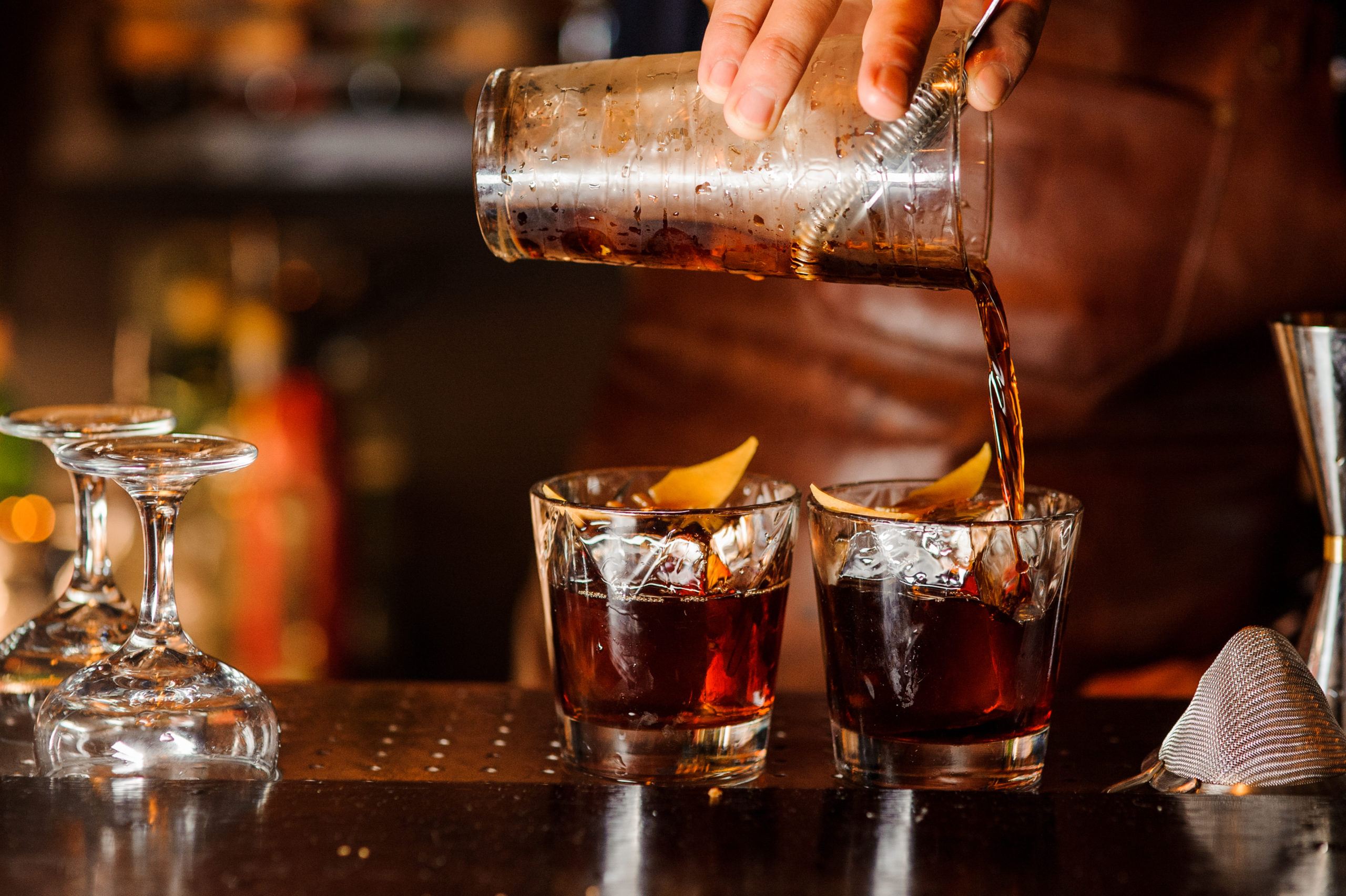 A bartender pouring two drinks at once