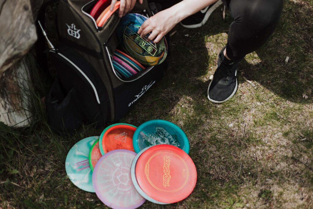 golf discs on ground next to backpack